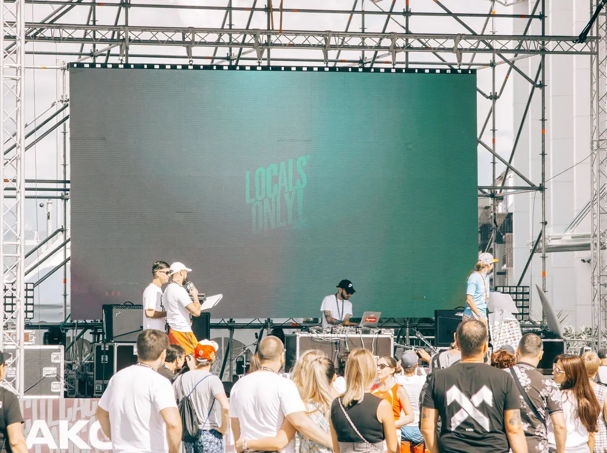 Escenario al aire libre con pantalla LED, estructura y público — imagen referencial